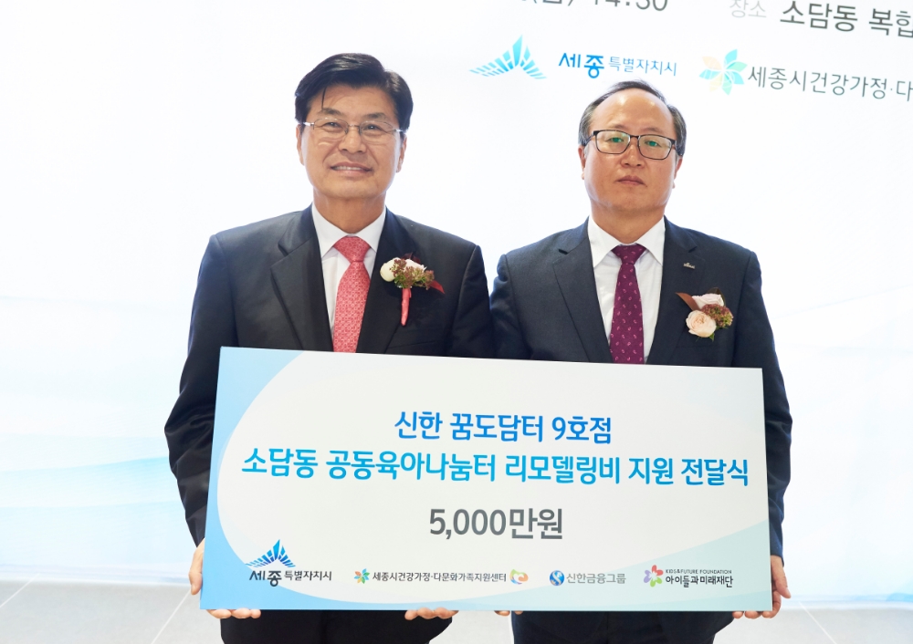 신한금융그룹은 19일 세종시 소담동 고운동에 위치한 공동육아나눔터에서 '신한 꿈도담터' 개소식을 진행했다. 이날 행사에서 세종시 이춘희 시장(사진 왼쪽)과 신한은행 대전충남본부 장용석 본부장이 기념 촬영을 하고 있다. / 사진= 신한금융지주