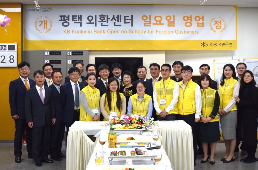 KB국민은행은 지난 28일, 경기 남부 지역 외국인근로자의 금융편의 제공을 위해 평택시에 '평택 외환센터'를 개설했다. 앞줄 왼쪽부터 세번째 김우영 평택외국인복지센터장, 맨뒷줄 왼쪽부터 여섯번째 이길성 KB국민은행 외환사업본부 상무, 맨뒷줄 왼쪽부터 여덟번째 공승배 KB국민은행 경수지역영업그룹 대표. / 사진= KB국민은행