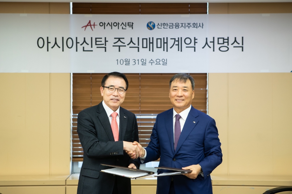 신한금융지주는 31일 서울 강남구 역삼동에 위치한 법무법인 태평양 사무실에서 아시아신탁(주)과 주식매매계약(SPA)를 체결했다. 이날 체결식에서 신한금융그룹 조용병 회장(사진 왼쪽)과 아시아신탁 정서진 부회장이 기념 촬영을 하고 있다. / 사진= 신한금융지주