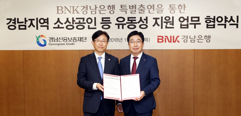 BNK경남은행 황윤철 은행장(사진 오른쪽)가 경남신용보증재단 구철회 이사장과 ‘경남지역 소상공인 등 유동성 지원 업무협약’을 체결한 뒤 기념촬영하고 있다. / 사진= BNK경남은행