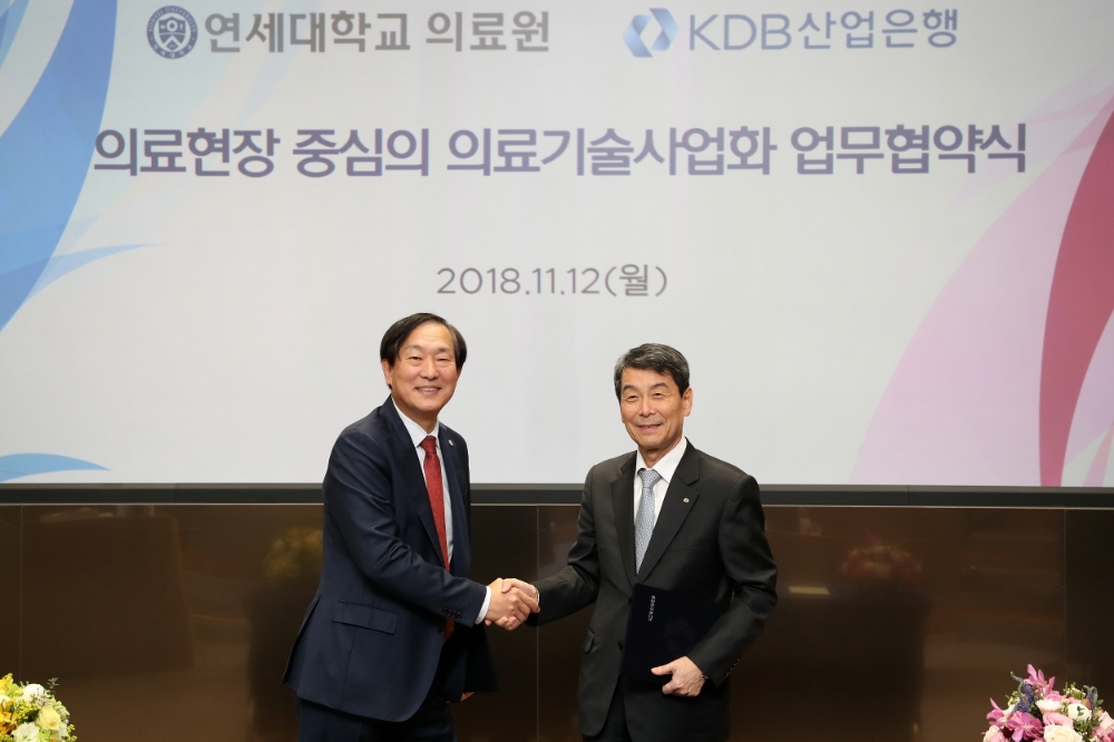 이동걸 산업은행 회장(오른쪽)이 12일 여의도 산업은행 본점 1층 IR센터에서 윤도흠 연세대학교의료원장과 의료현장 중심의 의료기술사업화 촉진을 위한 업무협약을 체결하고 악수를 하고 있다. / 사진= 산업은행