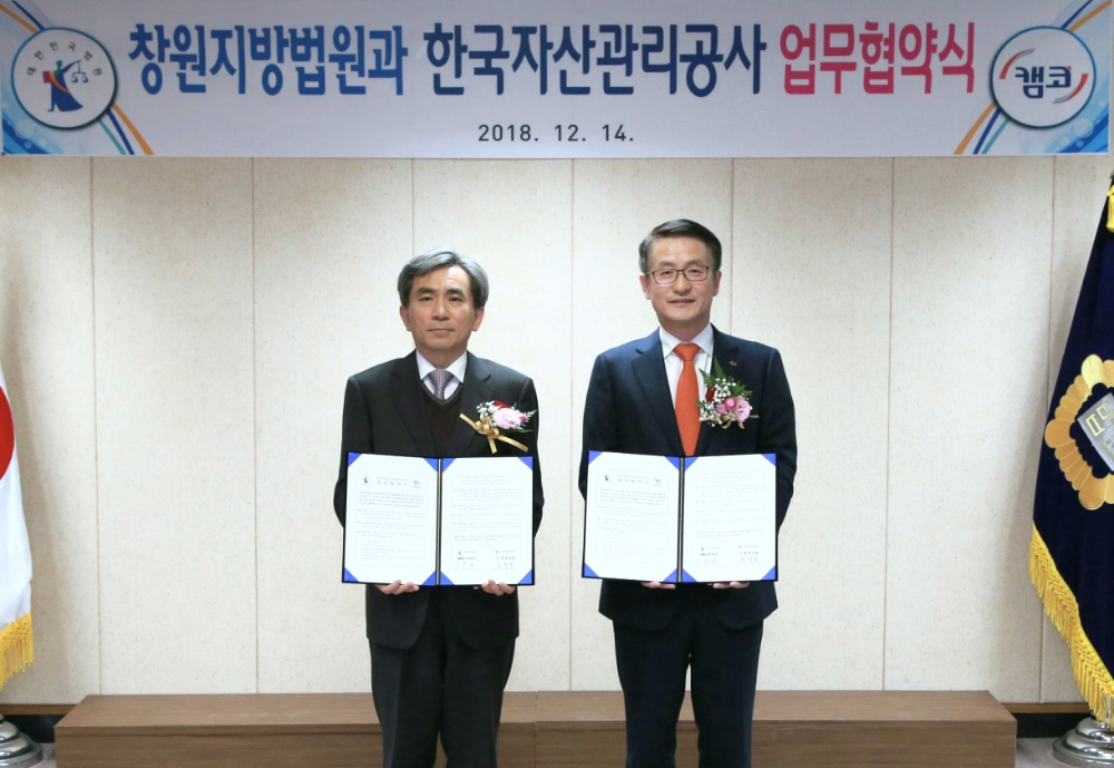 △14일 오후 5시 창원지방법원 본관 5층 소회의실에서 문창용 캠코 사장(오른쪽)과 박효관 창원지방법원장(왼쪽)이 참석한 가운데 회생기업에 대한 효율적인 구조조정 및 개인회생․파산절차 상호협력을 위한 업무협약을 체결하고 기념촬영을 하고 있다./사진=캠코