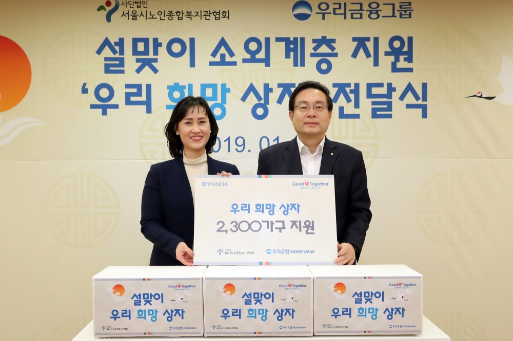 우리금융그룹은 18일 오후 서울 중구 본점에서 손태승 회장과 200여명의 신입행원들이 소외계층을 위한 설맞이 '우리희망상자' 2300개를 직접 제작해 서울시 노인종합복지관협회에게 전달했다. 손태승 우리금융그룹 회장(사진 오른쪽)이 성미선 서울시 노인종합복지관협회장과 기념 촬영을 하고 있다. / 사진= 우리은행