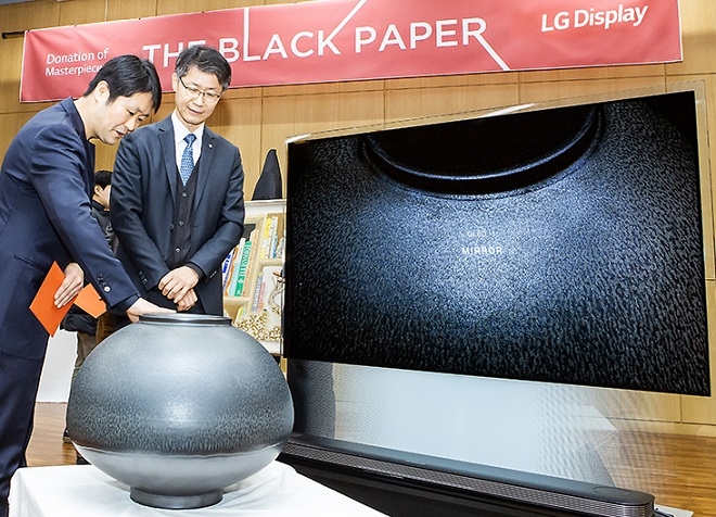 한정용 교수(왼쪽)가 OLED TV 콜라보를 통해 제작된 '검은 달항아리' 작품 설명을 하고 있다. (사진=LGD)