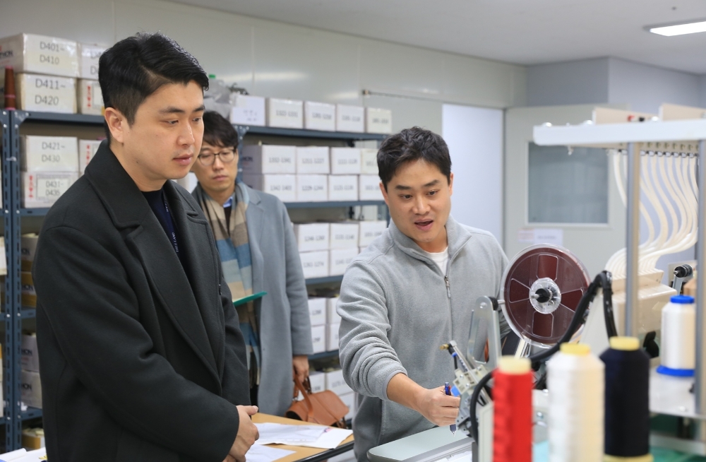 이랜드월드 패션사업부 최운식 대표(사진 왼쪽)가 지난 달 31일, 노원구 공릉동에 위치한 동원물산에 방문하여 송강경 부장(사진 오른쪽)으로부터 자수기계에 대한 설명을 듣고 있다. /사진제공=이랜드