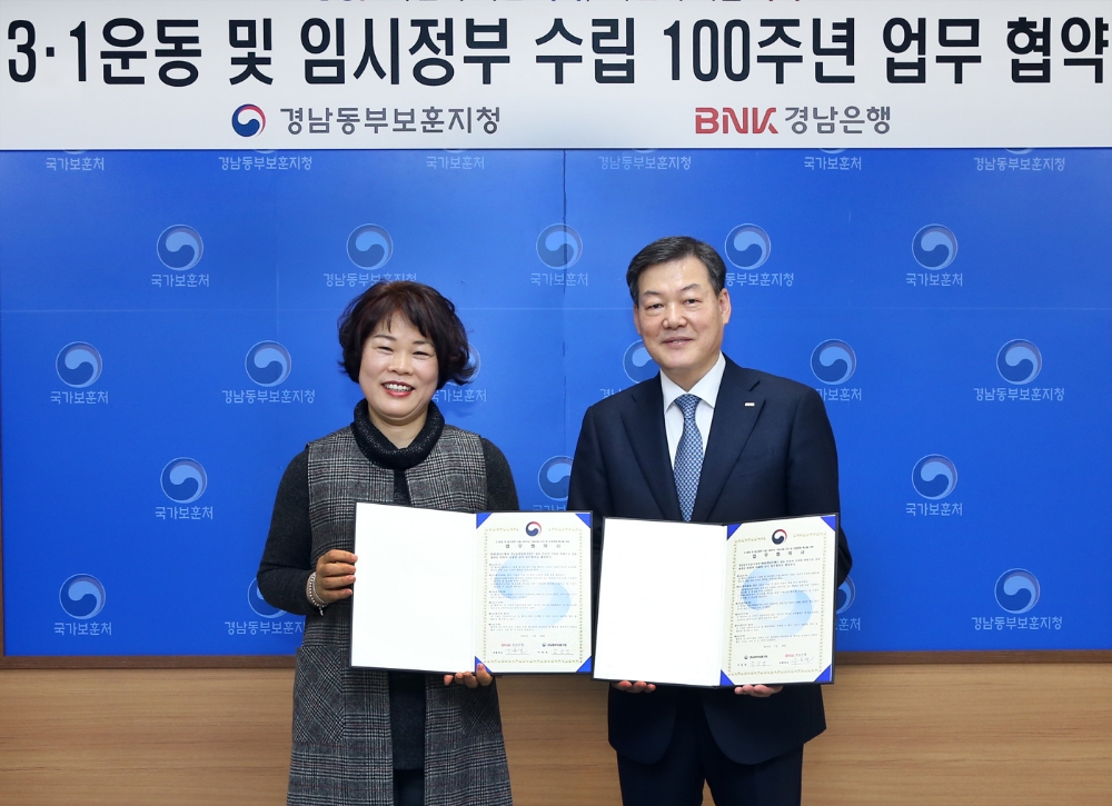 BNK경남은행 유충렬 그룹장(사진 오른쪽 세번째)이 경남동부보훈지청 김남영 지청장(사진 왼쪽 세번째)과 3ㆍ1운동 100주년 기념 사회공헌 업무협약을 체결하고 있다./사진=BNK경남은행