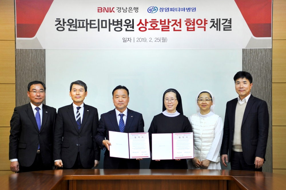 BNK경남은행 한기환 그룹장(사진 왼쪽 세번째)이 창원파티마병원 박정순 병원장(사진 오른쪽 세번째)과 상호발전 업무 협약을 체결하고 있다./사진=BNK경남은행