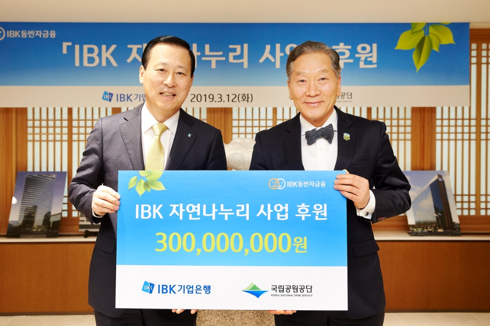 12일 을지로 기업은행 본점에서 김도진 기업은행장(왼쪽)과 권경업 국립공원공단 이사장이 ‘IBK 자연나누리 사업’ 후원금 전달식을 마치고 기념촬영을 하고 있다. / 사진= 기업은행