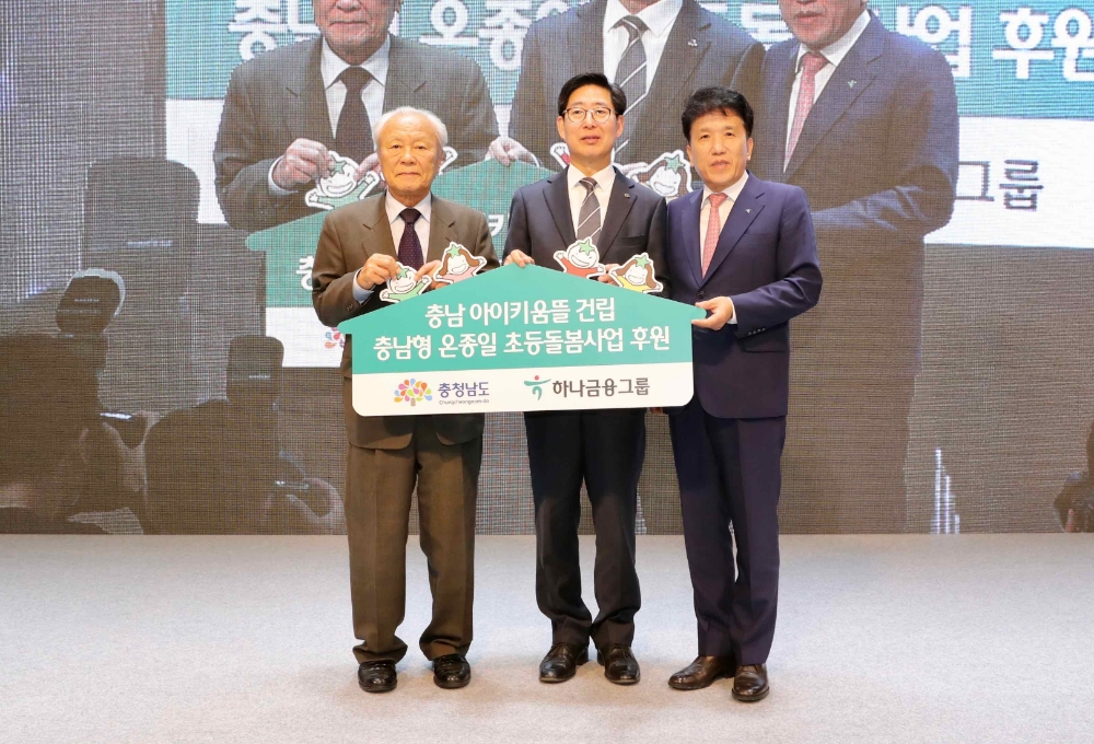 하나금융그룹은 23일 충청남도와 함께 충남 홍성에 위치한 ‘충남아이키움뜰’ 어린이집의 개원식을 진행했다.어린이집 개원식에 앞서 충남도립도서관 대강당에서 개최된 충청남도 아이키우기 좋은 비전 선포식에 참석하여 온종일 돌봄체계 구축사업을 위한 지원금을 전달했다. 박승 하나금융그룹 사회공헌위원장(사진 왼쪽), 함영주 하나금융그룹 부회장(사진 오른쪽), 양승조 충청남도 도지사(사진 가운데)가 지원금 전달식 후 기념촬영을 하고 있다. / 사진= 하나금융지주