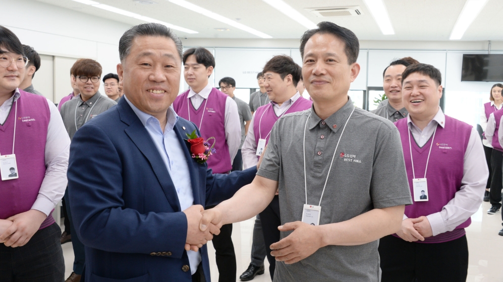 △LG전자가 2일 서울 강서구에 위치한 강서서비스지점에서 진행한 LG전자 서비스 직고용 한가족 행사에서 배상호 노조위원장이 서비스지점 직원들에게 LG뱃지를 달아주며 축하인사를 건네고 있다/사진=LG전자