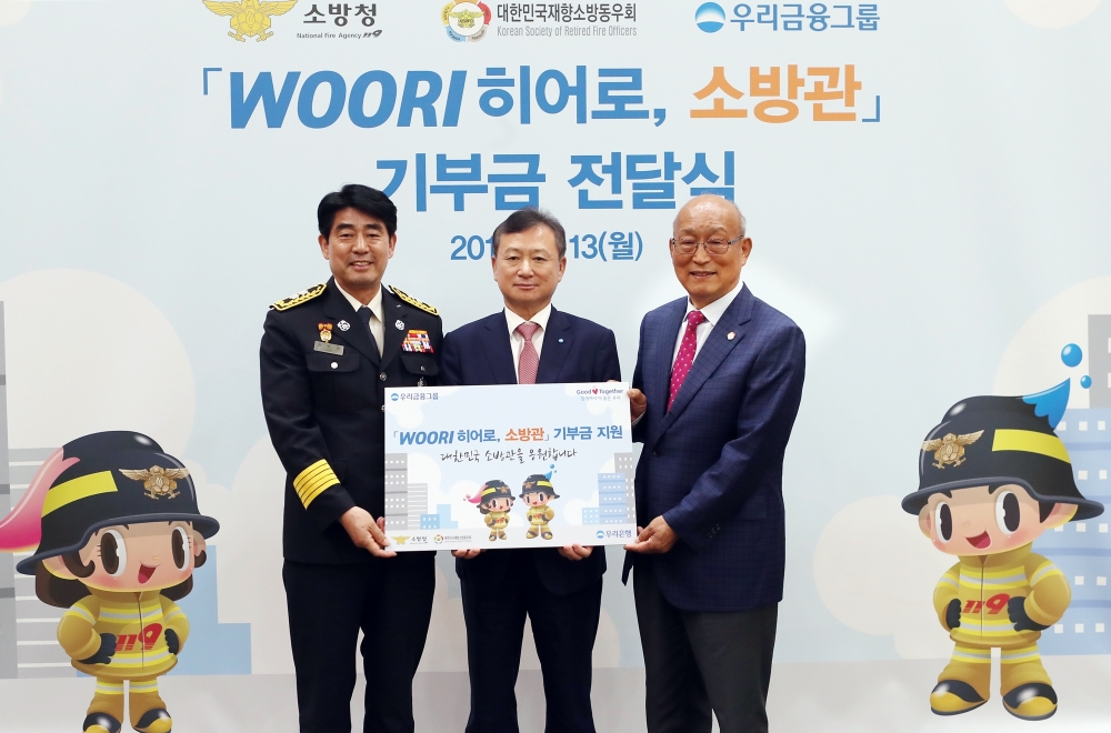 조수형 우리은행 소비자브랜드그룹장(사진 가운데)이 최병일 소방청 소방정책국장(사진 왼쪽), 오세억 대한민국재향소방동우회 회장과 기념촬영을 하고 있다./사진=우리금융그룹