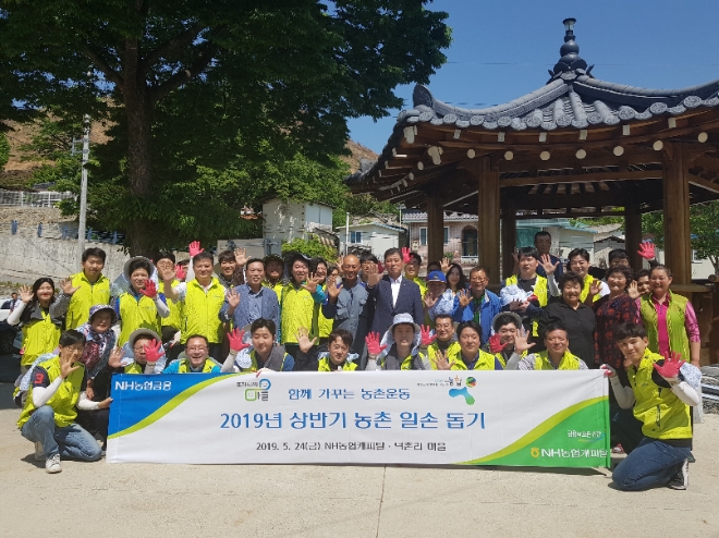 24일 충북 단양군 대강면 덕촌리에서 진행된 'NH농협캐피탈 2019년 상반기 농촌 일손 돕기' 활동에서 이구찬 대표(사진 2번째 줄 왼쪽부터 6번째)과 임직원 봉사단이 일손돕기 시작 전 기념촬영을 하고 있다. / 사진 = NH농협캐피탈