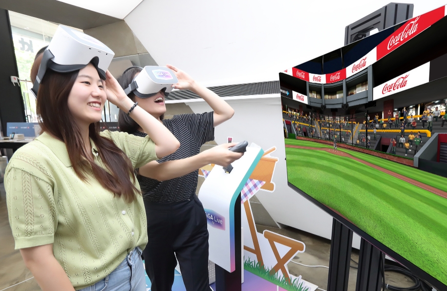 △KT 모델들이 기가라이브TV를 이용해 VR 스포츠 게임을 즐기는 동시에 게임 속 경기장 전광판과 배너를 통해 노출되고 있는 VR 광고를 체험하고 있다/사진=KT 