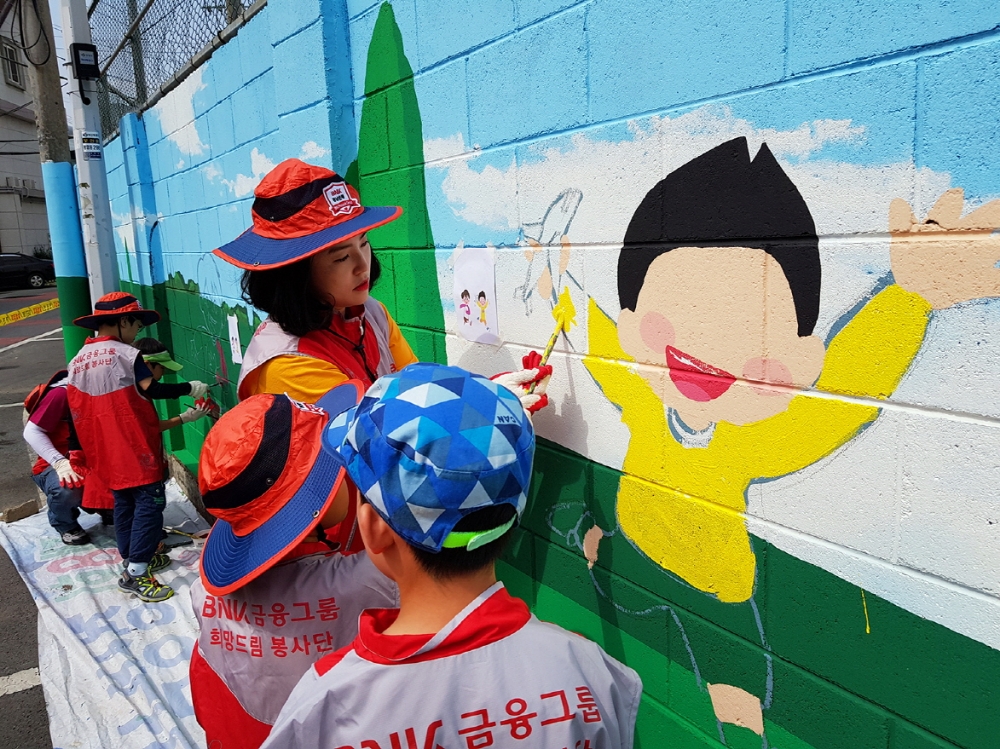 경남은행 임직원이 지난 22일 벽화 그리기 봉사를 하고 있다./사진=경남은행