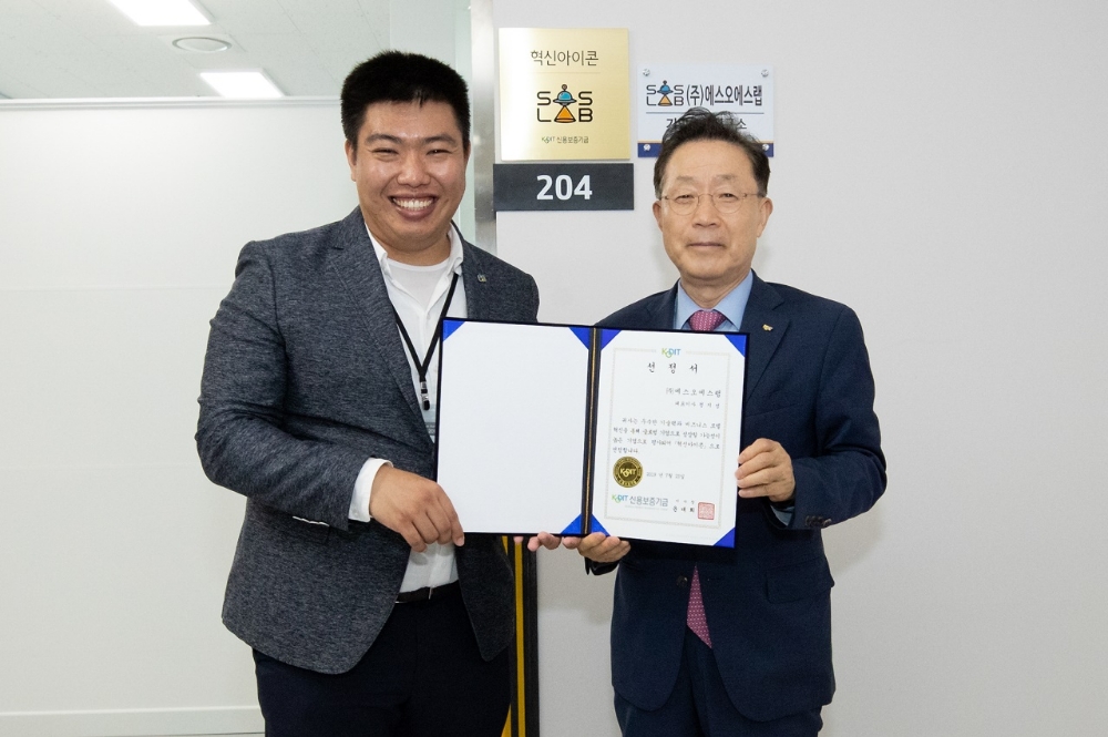 윤대희 신용보증기금 이사장(오른쪽)이 유니콘기업 육성을 위해 올해 새롭게 도입한 ‘제1기 혁신아이콘’ 선정기업인 에스오에스랩을 23일 방문해 정지성 대표이사(왼쪽)에게 선정서를 수여하고 기념촬영을 하고 있다./사진=신용보증기금