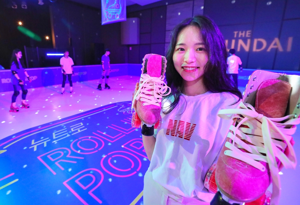 24일 오전 현대백화점 목동점 7층 토파즈홀에 마련된 '뉴트로 롤링팝' 롤러장에서 직원이 행사를 소개하고 있다. /사진제공=현대백화점