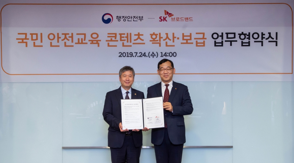 △24일 SKT 성수사옥에서 윤원영 SK브로드밴드 운영총괄(오른쪽)과 김계조 행정안전부 재난안전관리본부장(왼쪽)이 안전문화 확산을 위한 업무협약 체결식을 하고 기념촬영 하는 모습/사진=SK브로드밴드