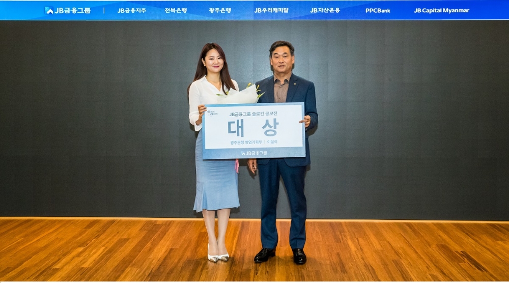 김기홍 JB금융지주 회장(오른쪽)이 JB금융 새 슬로건 공모전에 선정된 이설희 광주은행 행원에 시상 후 기념촬영을 하고 있다./사진=JB금융지주