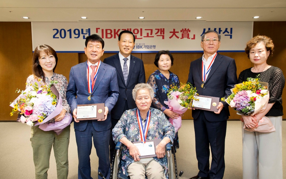 29일 서울 을지로 본점에서 김도진 기업은행장(왼쪽 세 번째), 안현자 고객(가운데), 김수영 고객(오른쪽 두 번째), 김영식 고객(왼쪽 두 번째)과 가족들이 ‘IBK 개인고객 대상’ 시상식을 마치고 기념촬영을 하고 있는 모습. / 사진= IBK기업은행