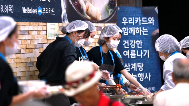 우리카드 직원과 인턴사원들이 지난 8일 서울시 중구 신당데이케어센터에서 저소득층 어르신을 모시고 삼계탕과 수박을 대접하는 봉사 활동을 실시했다. / 사진 = 우리카드