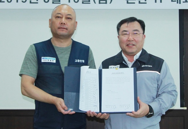 쌍용자동차 예병태 대표이사(오른쪽)와 정일권 노동조합위원장이 임금협상 합의서에 서명한 뒤 기념촬영을 하고 있다. (사진=쌍용차)