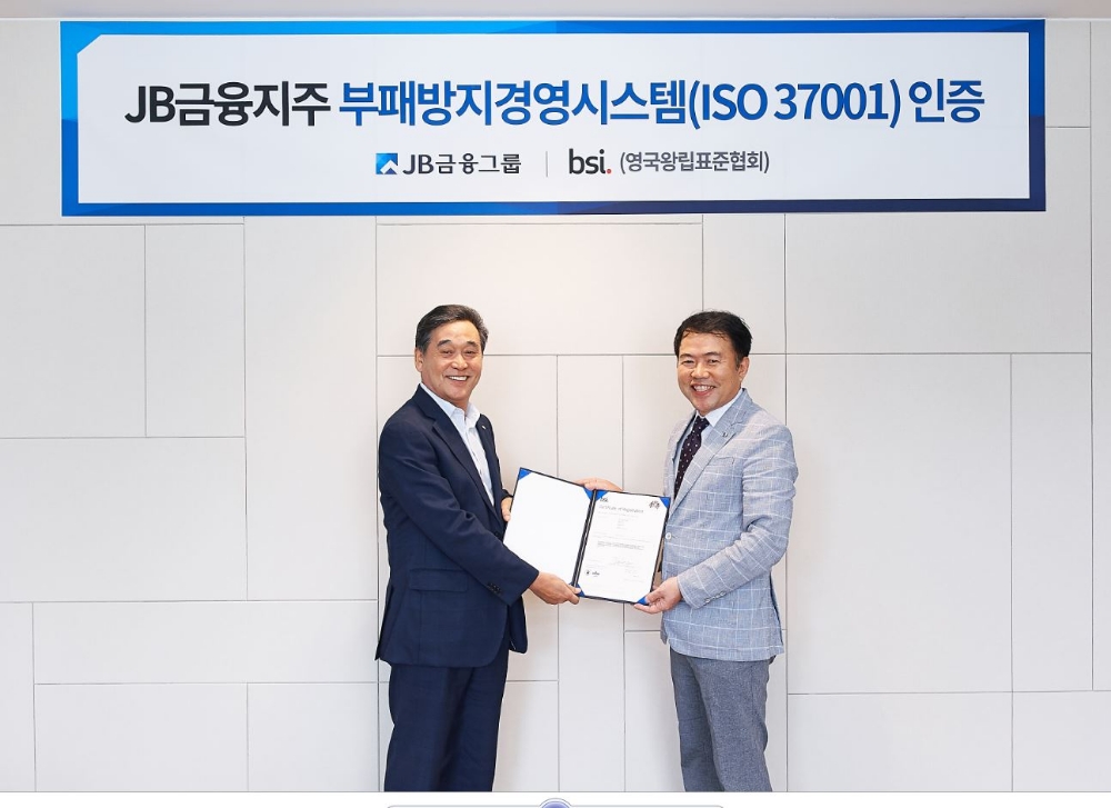 김기홍 JB금융그룹 회장(왼쪽)이 BSI 코리아 송경수 총괄 책임으로부터 지난 8월 30일 서울 여의도 JB빌딩에서 'ISO 37001' 인증서를 수여받고 있다./사진=JB금융지주