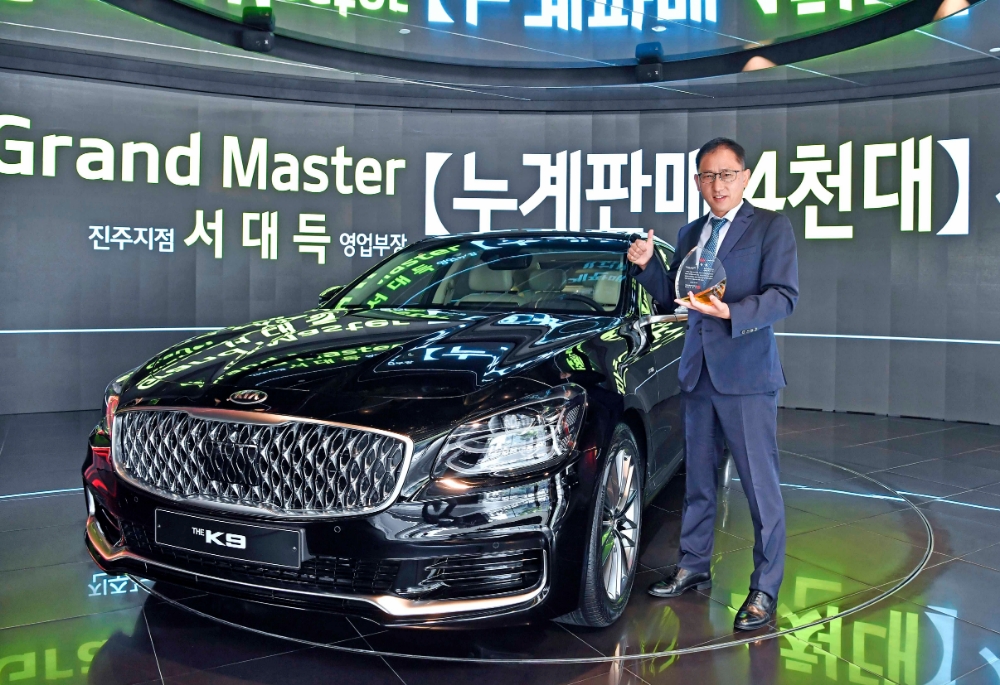 누계판매 4000대를 달성한 경남 진주지점 서대득 영업부장이 수상받은 K9 앞에서 포즈를 취하고 있다. (사진=기아차)