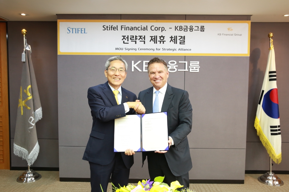 21일 서울 여의도 KB국민은행 본점에서 윤종규 KB금융그룹 회장(좌측), 론 크루셰프스키 스티펠 파이낸셜 회장(우측)이 전략적 제휴를 위한 양해각서(MOU) 체결 후 기념사진을 촬영하고 있다. / 사진= KB금융지주