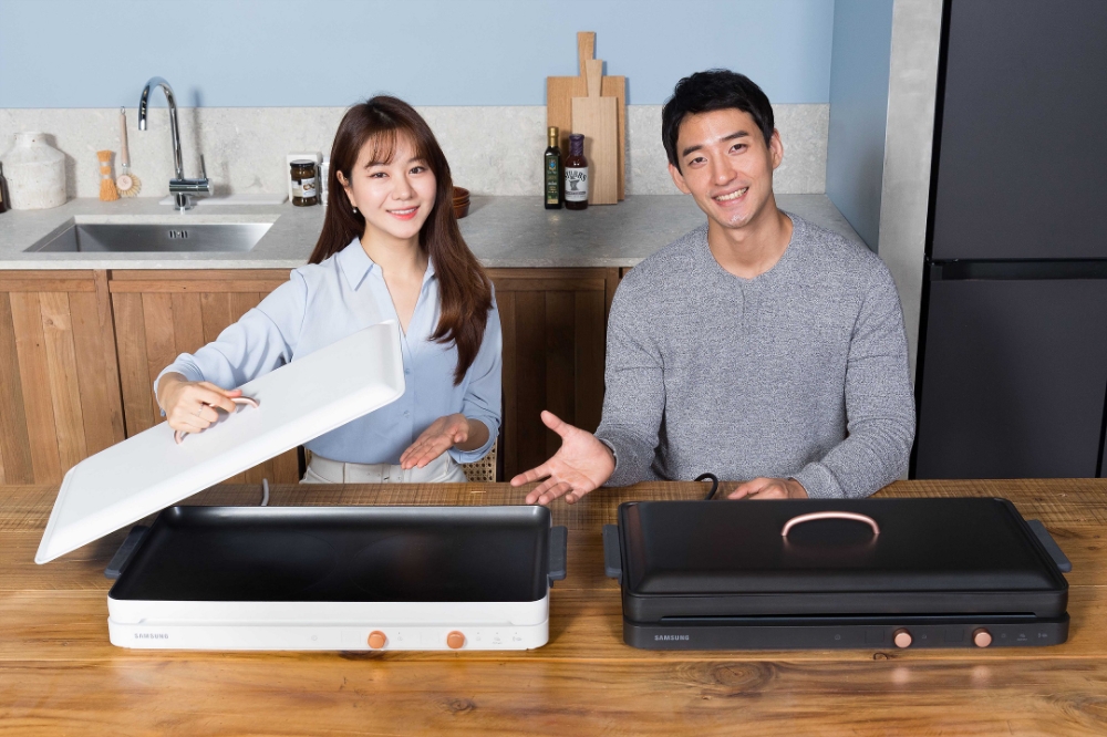 △삼성전자 모델들이 인덕션 더 플레이트 화이트, 블랙 두 가지 색상 기기를 홍보하고 있다/사진=삼성전자