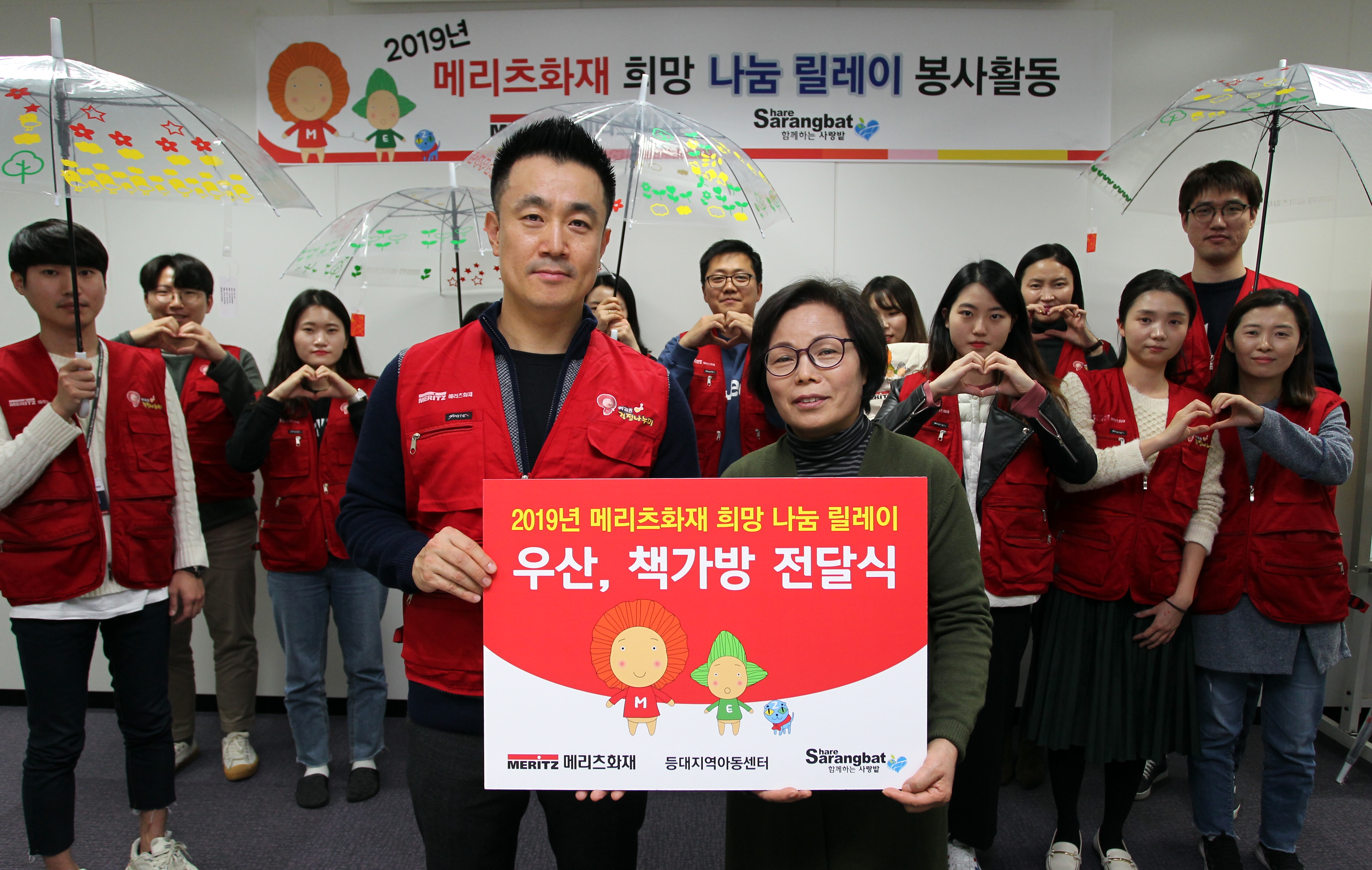 지난 26일 메리츠화재 임직원들이 투명우산 및 책가방을 만들어 김효순 중구 등대지역아동센터장(오른쪽)에게 전달하고 있다. / 사진 = 메리츠화재