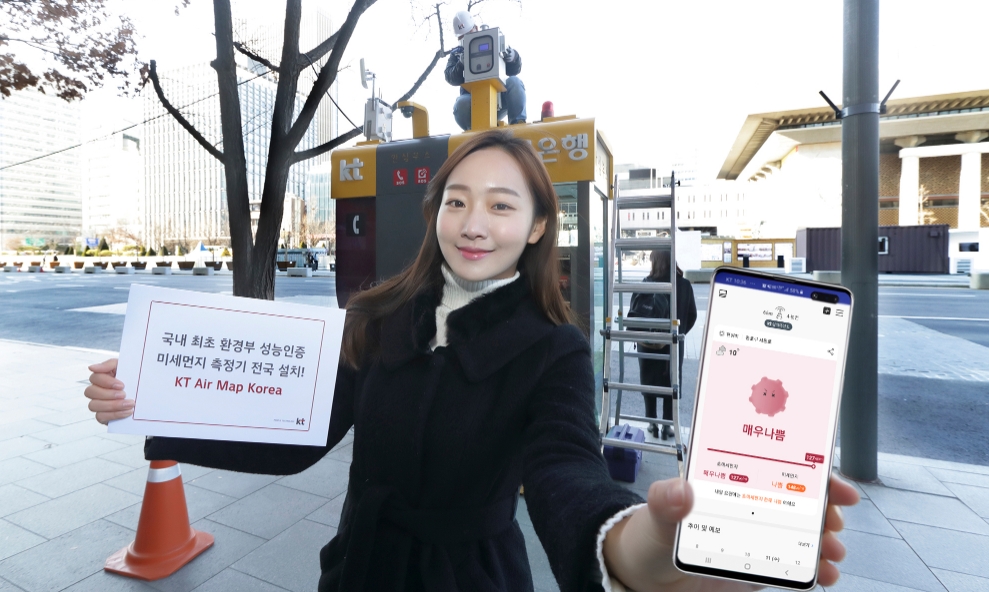 KT 관계자가 광화문 KT 사옥 앞에 교체 설치된 미세먼지 측정소 앞에서 에어맵코리아 앱을 홍보하고 있다/사진=KT