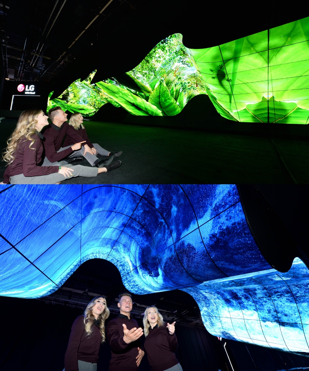 LG전자 모델들이 LG전자 전시관 입구에 마련된 올레드 조형물을 보고 감탄하고 있다/사진=LG전자