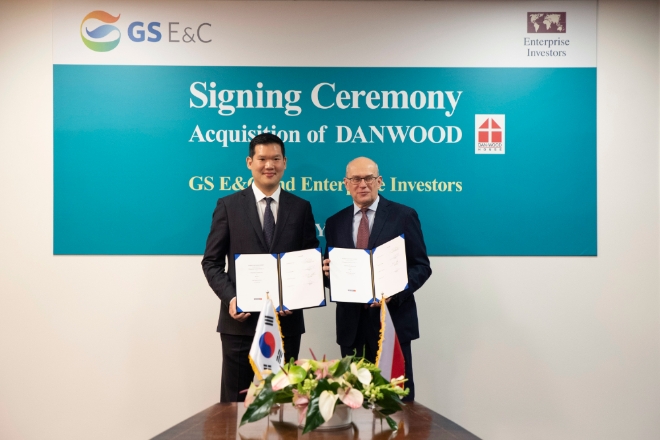 허윤홍 GS건설 사장이 20일(현지시각) 폴란드 단우드 본사에서 열린 인수 축하 행사에서 야첵 스비츠키 단우드 사장과 함께 인수를 마무리하는 서류에 서명 후 기념촬영 하고 있다. 제공=GS건설