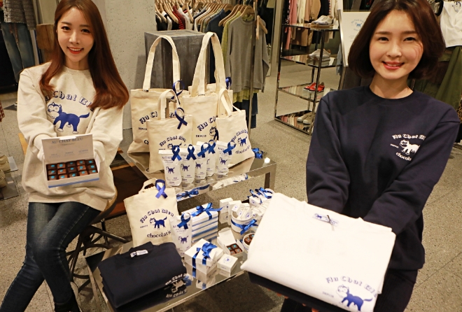 롯데백화점은 밸런타인데이를 맞아 본점, 잠실점 등 6개 점포 ‘비이커’ 매장에서 초콜릿 브랜드 ‘오 샤 블루’와 여성 패션 편집숍 ‘비이커’가 협업해 만든 맨투맨 티셔츠와 에코백을 선보인다. /사진=롯데그룹.