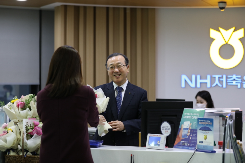 14일 강남구 소재 NH저축은행 본점영업부에서 실시한 ‘꽃 나눔 행사’에서 김건영 대표이사(사진 가운데)가 영업점 내방고객에게 꽃을 나눠주고 있다./사진=NH저축은행