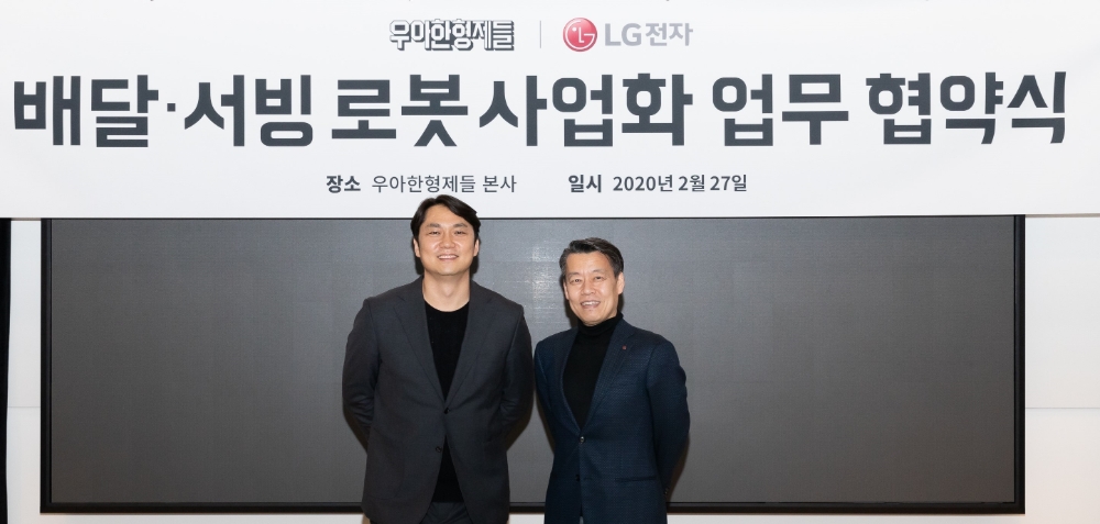 노진서 LG전자 로봇사업센터장 전무(오른쪽)와 윤현준 우아한형제들 신사업부문장 부사장(왼쪽)이 기념촬영을 하고 있다/사진=LG전자
