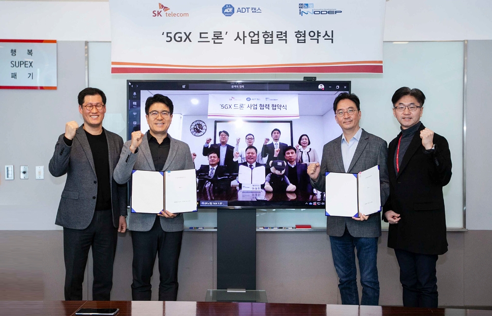 박진효 SK텔레콤 보안사업부장(ADT캡스 대표 겸임, 왼쪽서 2번째)과 김윤 CTO(오른쪽서 2번째), 이성진 이노뎁 대표(영상 속 앞줄 가운데) 등 관계자들이 통신망 기반 드론 시장 선도를 위한 적극 협력을 다짐하고 있다. 제공=SK텔레콤