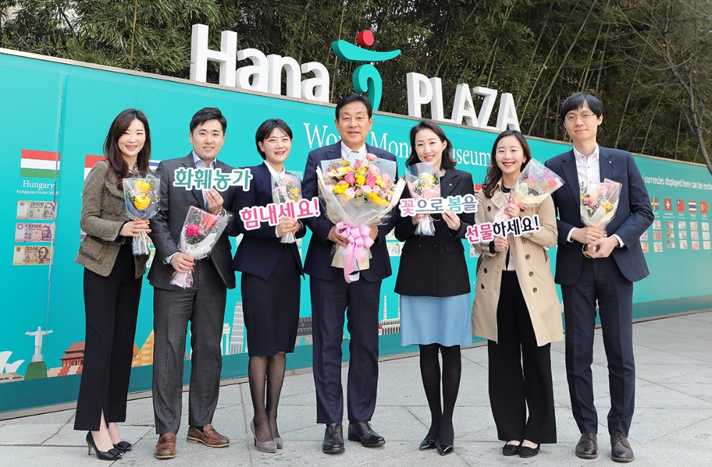 △ 김정태 하나금융 회장(가운데)이 명동 사옥에서 임직원들에게 꽃을 선물하고 기념촬영을 하고 있다. /사진=하나금융그룹
