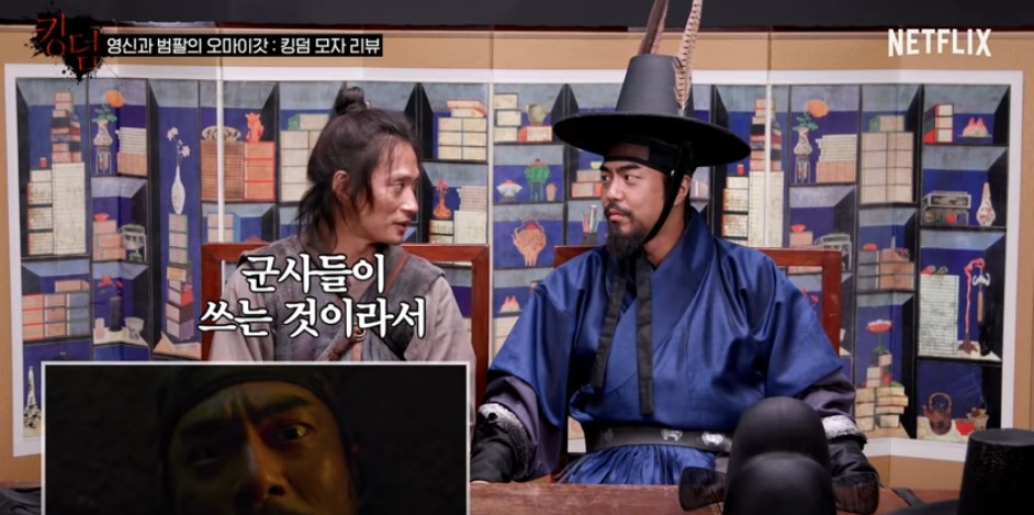 킹덤2 오마이갓 영상에서 조범팔 역의 전석호 배우가 군사들의 갓 주립을 쓰고 영신 역의 배우 김성규와 관련 대화를 나누고 있다/사진=오승혁 기자(넷플릭스 유튜브 영상 편집)