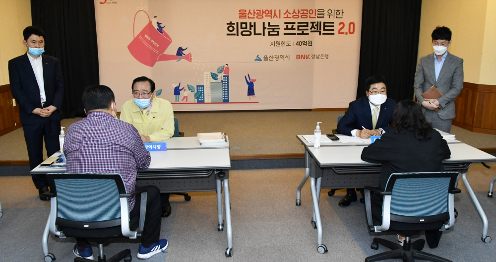 △ 황윤철 BNK경남은행장(오른쪽)과 송철호 울산시장(왼쪽)이 희망나눔 프로젝트 2.0을 찾은 지역 소상공인들에게 금융상담을 하고 있다. /사진=경남은행