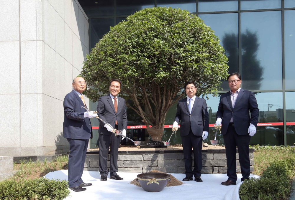 △ 황윤철 BNK경남은행장(오른쪽 두 번째)과 김지완 BNK금융그룹 회장(왼쪽 두 번째), 최광진 BNK경남은행노동조합 위원장(오른쪽 첫 번째), 최위승 ㈜무학 명예회장(왼쪽 첫 번째)이 ‘창립 50주년 식수’를 식재하고 있다. /사진=BNK경남은행