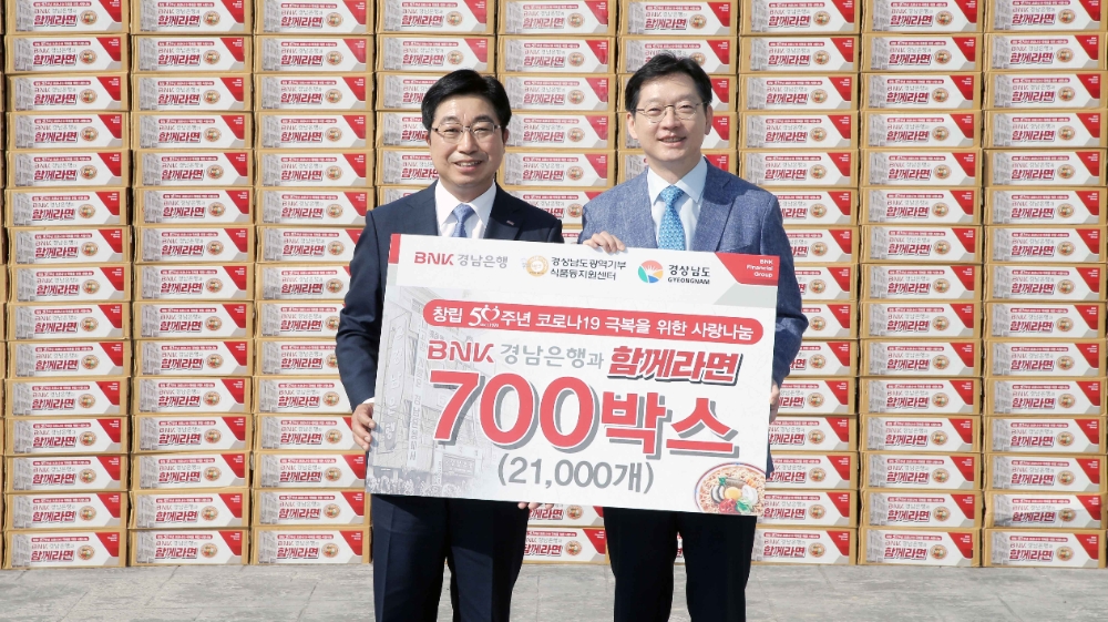 △ 황윤철 BNK경남은행장(왼쪽)이 김경수 경상남도지사(오른쪽)에게 ‘경남은행과 함께라면 700박스 기탁증서’를 전달하고 있다. /사진=경남은행