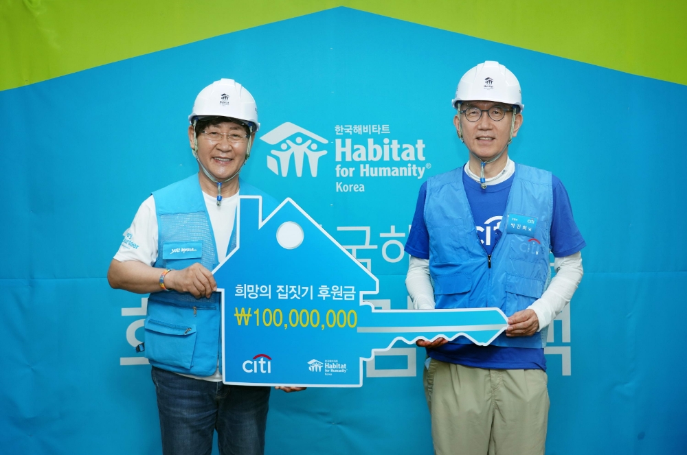 박진회 한국씨티은행장(오른쪽)이 윤형주 한국해비타트 이사장(왼쪽)에게 1억원의 후원금을 전달하고 있다.