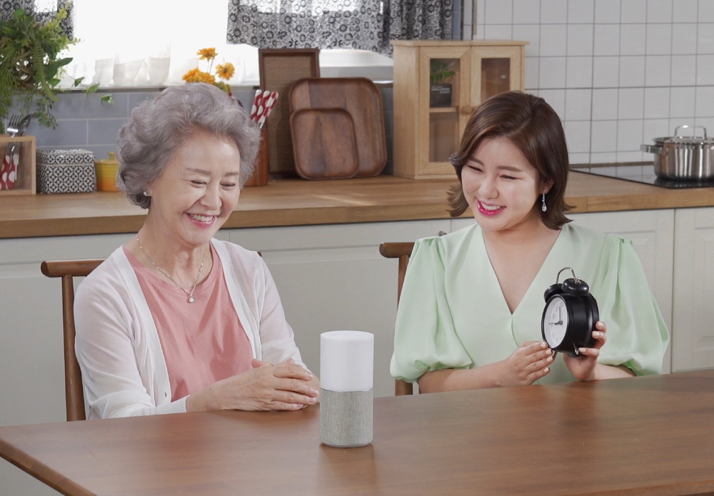 SK텔레콤이 어르신들의 건강하고 즐거운 삶을 지원하는 서비스 ‘누구 오팔(NUGU opal)’을 30일 출시했다. 사진은 인기 트로트 가수 송가인(오른쪽)이 어르신과 함께 '누구 오팔'을 사용하고 있는 모습/사진=SK텔레콤