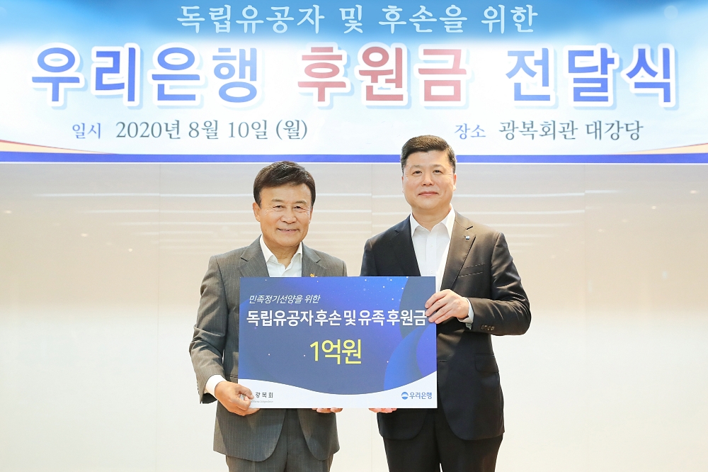 권광석(오른쪽) 우리은행장이 김원웅(왼쪽)과 후원금 1억원 전달 기념 촬영을 하고 있다./사진 제공 = 우리은행