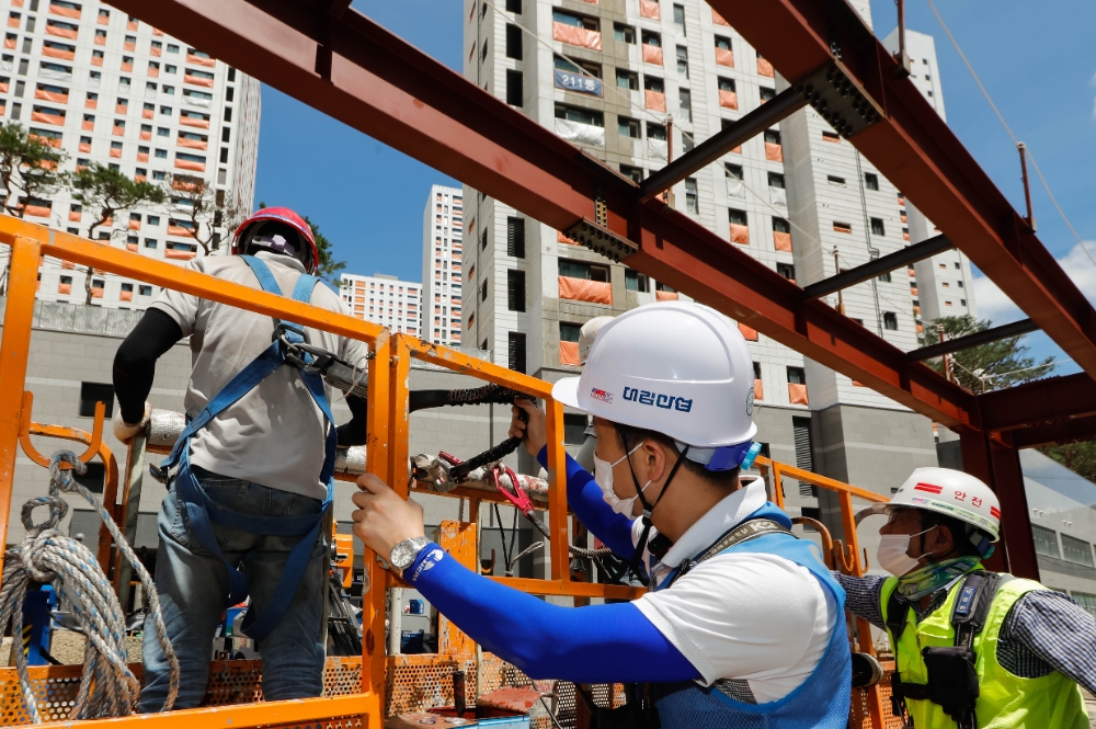 e편한세상 금정산 현장에서 대림산업 안전관리자와 협력회사 직원들이 안전벨트를 비롯한 보호구 착용을 점검하고 있다. / 사진=대림산업