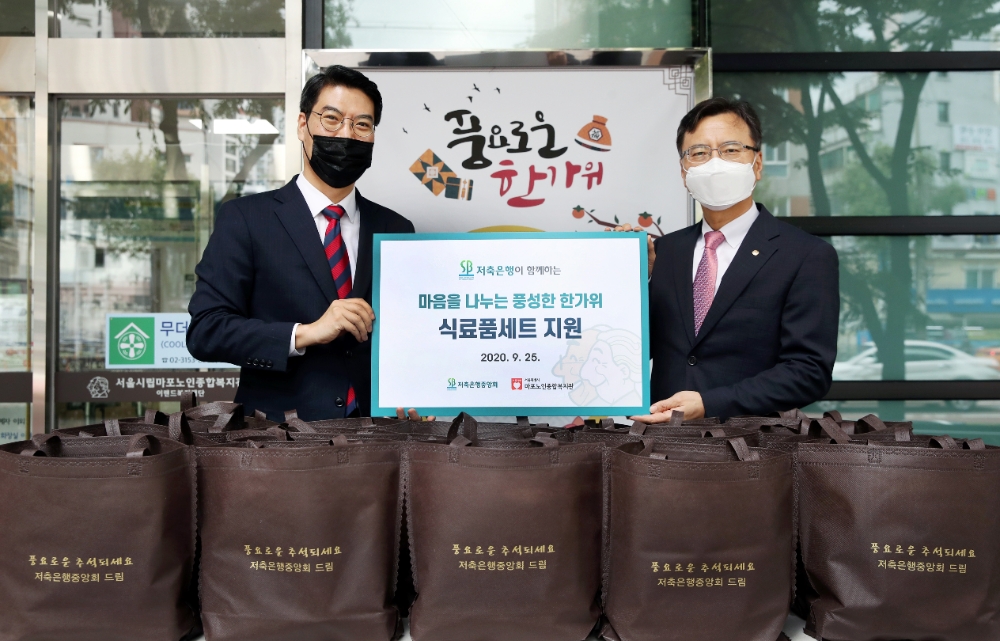 하은수 저축은행중앙회 전무(오른쪽)와 김윤태 시립마포노인종합복지관장(왼쪽)이 25일 식료품키트 전달식 후 기념 촬영을 하고 있다./사진=저축은행중앙회