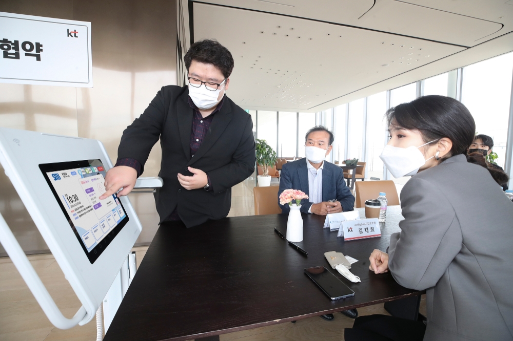업무협약식에서 참석자들이 AI 스마트병원 병상에 비치되는 AI 미디어테이블 등을 시연하고 있다./사진=KT