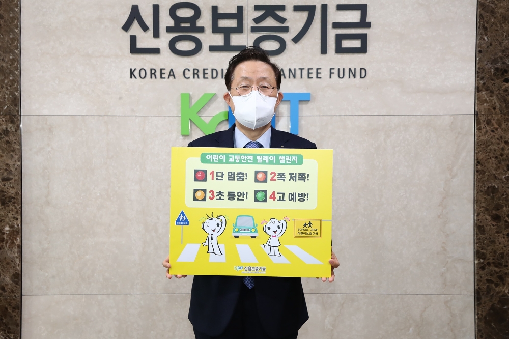 윤대희 신용보증기금 이사장이 1일 ‘1단 멈춤! 2쪽 저쪽! 3초 동안! 4고 예방!’ 교통안전 표어를 들고 ‘어린이 교통안전 릴레이 챌린지’에 동참하고 있다./사진=신용보증기금