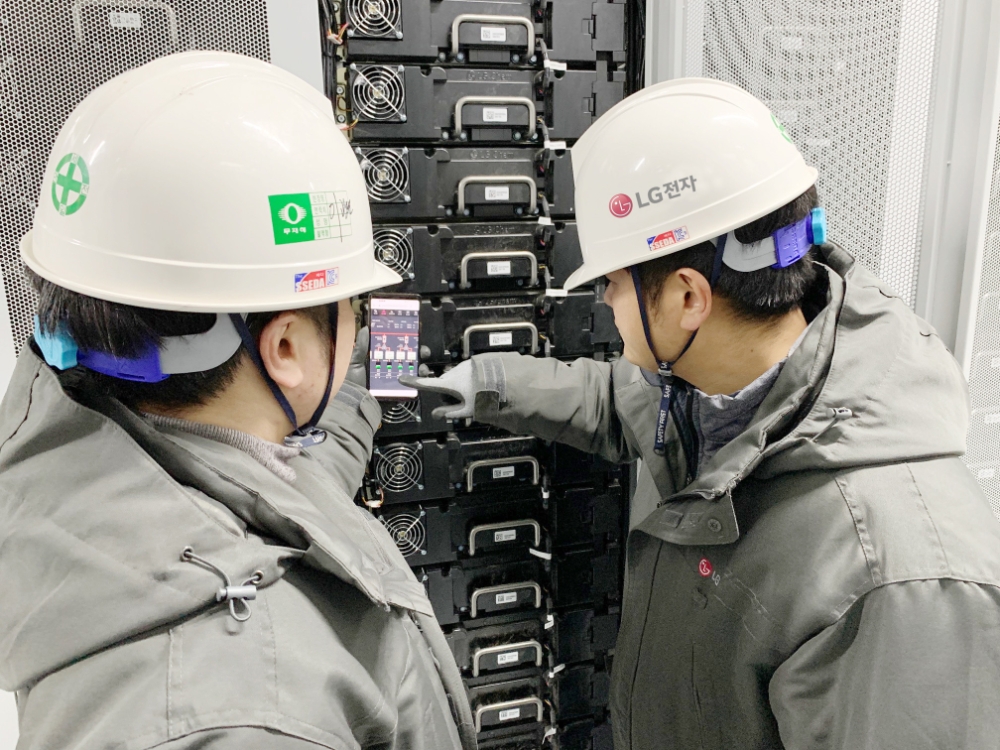 LG전자 직원들이 전남 신안군 안좌스마트팜앤쏠라시티에 구축한 에너지저장장치(ESS)의 동작상황을 스마트폰을 통해 확인하고 있다. 사진=LG전자
